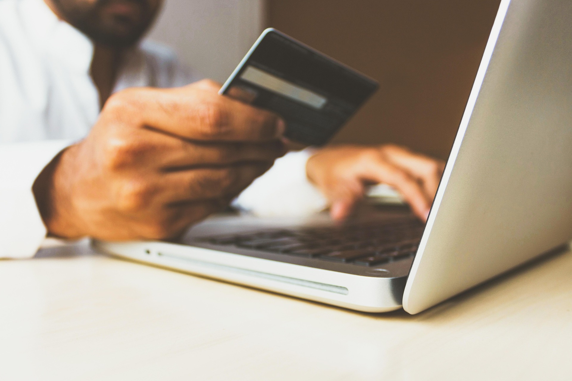 Customer managing everyday money with a card and a laptop